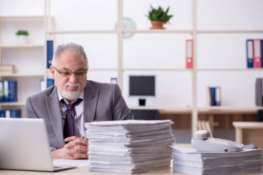 Ofisteki aşırı işten memnun olmayan yaşlı bir erkek işçi.