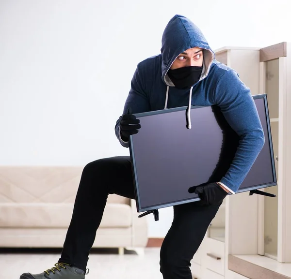 Homme cambrioleur voler le téléviseur de la maison — Photo