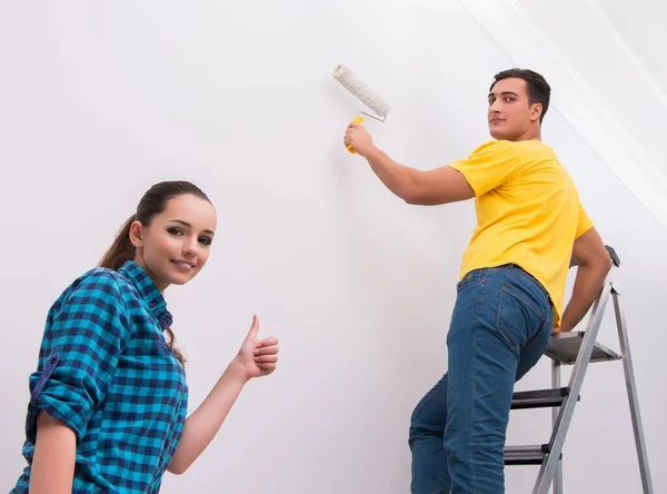 Unga par målning vägg hemma — Stockfoto