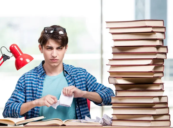 Student z mnóstwem książek przygotowujących do egzaminów — Zdjęcie stockowe