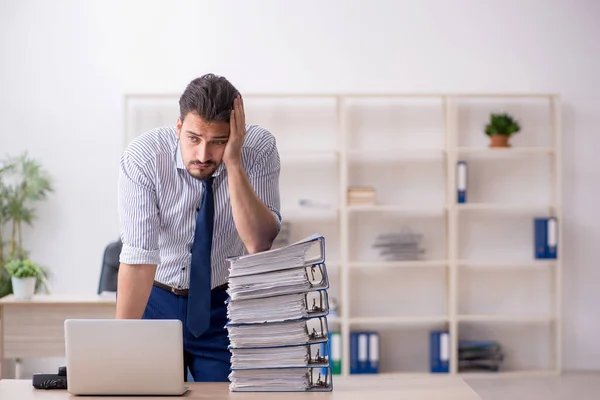 Jeune employé masculin et trop de travail au bureau — Photo