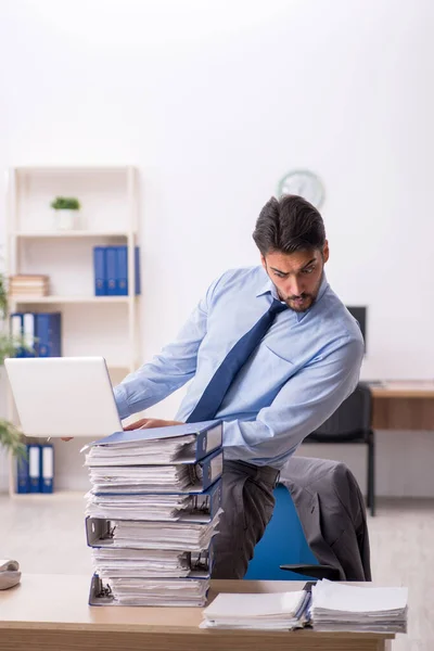 Jeune employé masculin et trop de travail au bureau — Photo