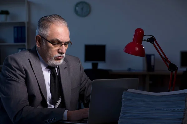 Alte männliche Angestellte arbeiten spät im Büro — Stockfoto