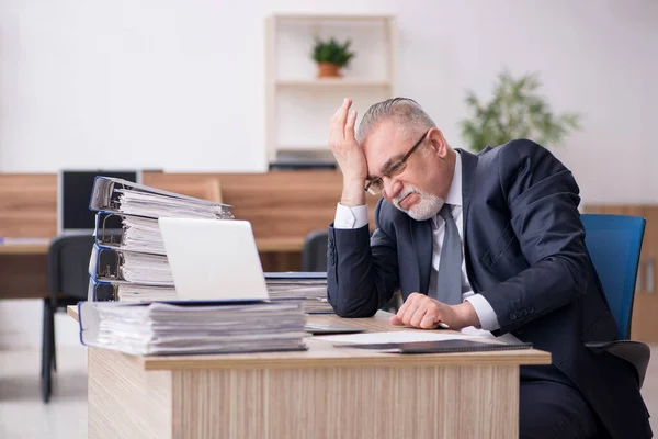 Hombre anciano empleado sentado en el lugar de trabajo — Foto de Stock