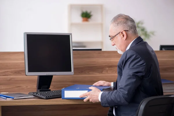 Gammal manlig anställd som sitter på arbetsplatsen — Stockfoto