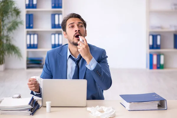 Giovane dipendente maschile che soffre sul posto di lavoro — Foto Stock