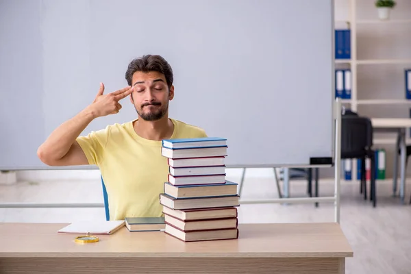 Joven estudiante masculino preparándose para los exámenes en el aula — Foto de Stock