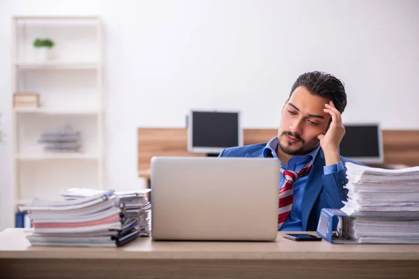 Jovem trabalhador masculino infeliz com excesso de trabalho no local de trabalho — Fotografia de Stock