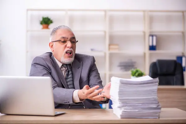 Alte männliche Mitarbeiter arbeiten am Arbeitsplatz — Stockfoto