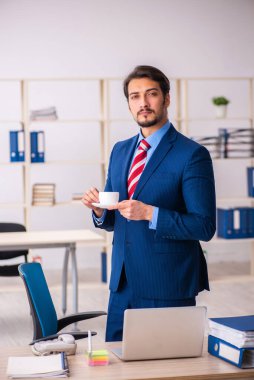 Molada kahve içen genç bir erkek.