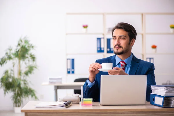 Jonge mannelijke werknemer die koffie drinkt tijdens de pauze — Stockfoto