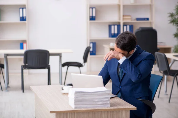 Jeune employé masculin et trop de travail au bureau — Photo