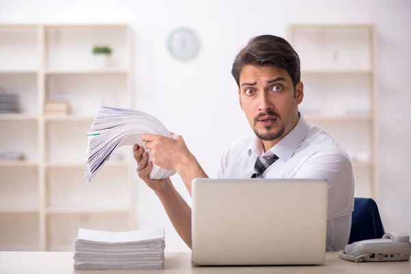 Jovem funcionário masculino infeliz com excesso de trabalho no escritório — Fotografia de Stock