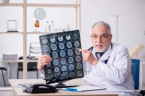 Gammal manlig röntgenläkare som arbetar på kliniken — Stockfoto