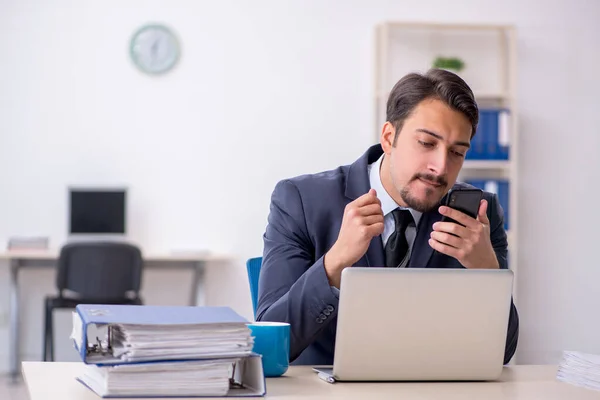 Empleado joven sentado en el lugar de trabajo — Foto de Stock