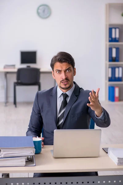 Giovane dipendente maschile seduto sul posto di lavoro — Foto Stock