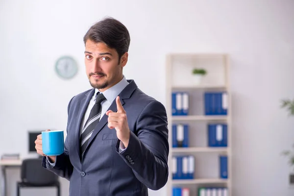 Joven empleado masculino bebiendo café durante el descanso — Foto de Stock