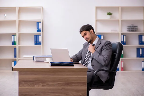 Ung attraktiv manlig anställd sitter på arbetsplatsen — Stockfoto