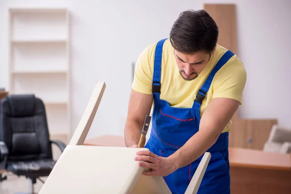 Genç erkek marangoz ofiste sandalye tamir ediyor. — Stok fotoğraf