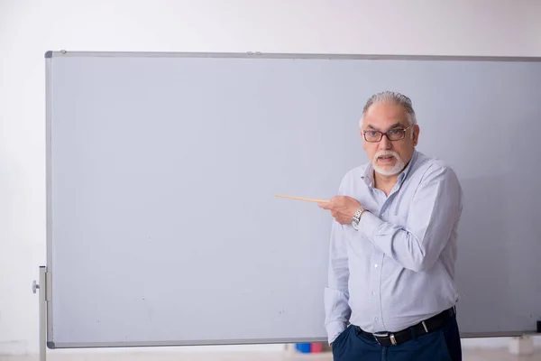 화이트보드 앞에 서 있는 늙은 남성 교사 — 스톡 사진