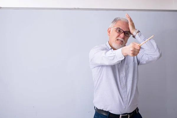 Velho professor masculino na frente do quadro branco — Fotografia de Stock