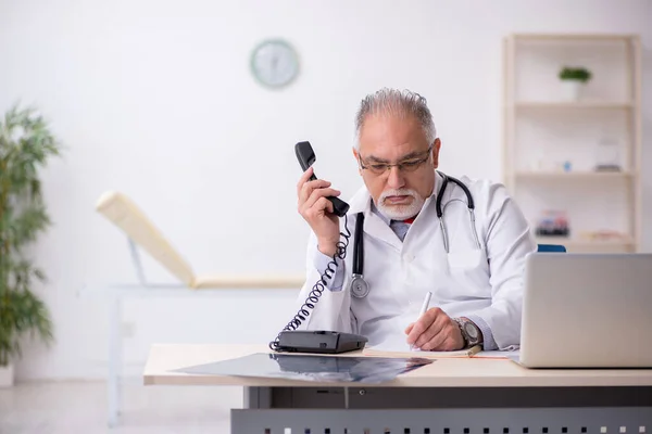 Klinikte çalışan yaşlı erkek doktor. — Stok fotoğraf