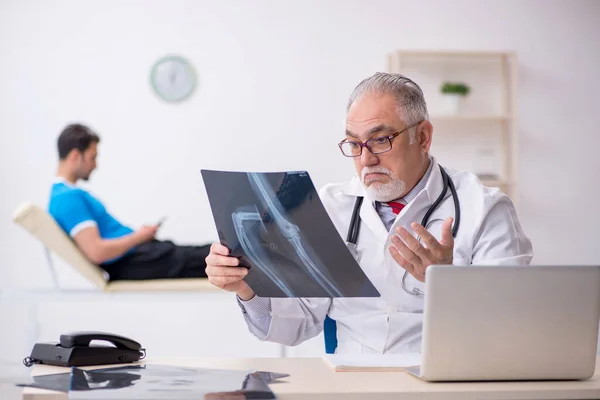 Paciente masculino joven que visita al radiólogo médico anciano — Foto de Stock