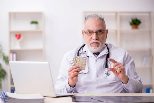 Öreg férfi orvos dolgozik a klinikán — Stock Fotó