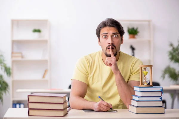 Joven estudiante masculino preparándose para los exámenes en la gestión del tiempo concep — Foto de Stock