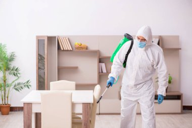 Young male contractor disinfecting at home