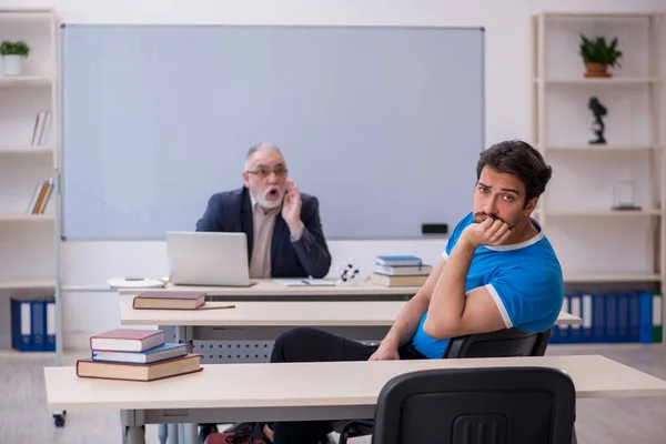 Gammel mannlig lærer og ung mannlig elev foran tavla – stockfoto