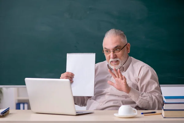 Oude mannelijke leraar voor schoolbord — Stockfoto