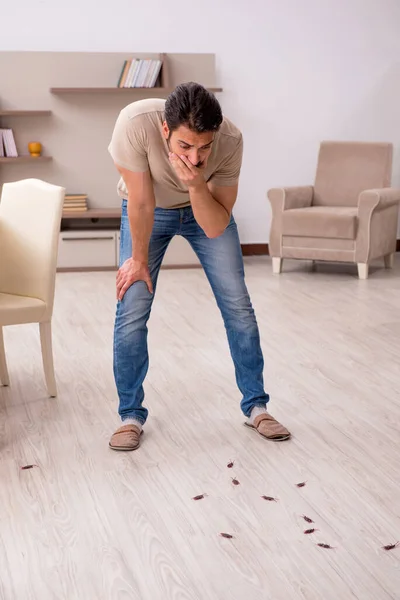 Jeune homme et beaucoup de cafards à la maison — Photo