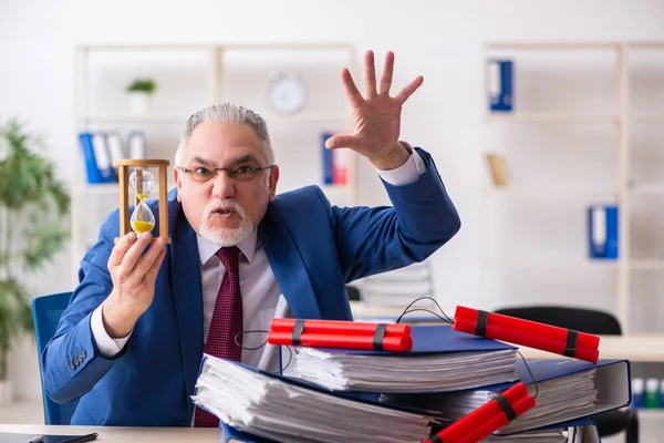 Velho funcionário masculino com dinamite no escritório — Fotografia de Stock