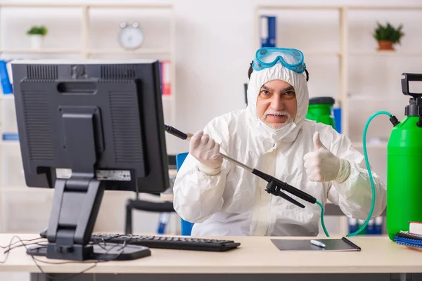 Old male contractor in office disinfection concept — Stock Photo, Image