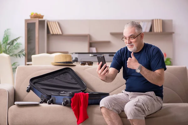 Old man preparing for trip at home — Stock Photo, Image