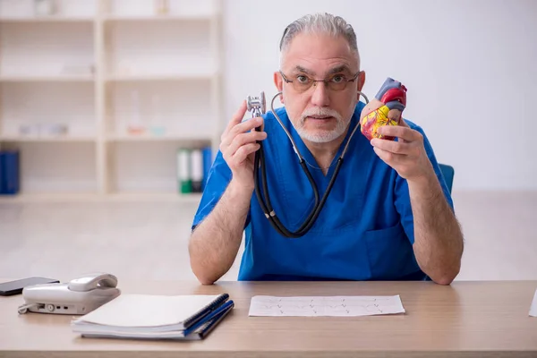 Klinikte çalışan yaşlı bir erkek kardiyolog. — Stok fotoğraf