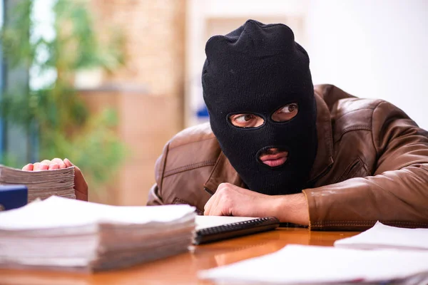 Junger Mann mit Sturmhaube stiehlt Informationen aus Büro — Stockfoto