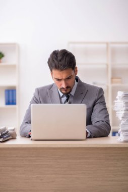 Ofisteki aşırı işten memnun olmayan genç bir erkek işçi.