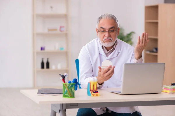 Vecchio dentista di sesso maschile che lavora in clinica — Foto Stock