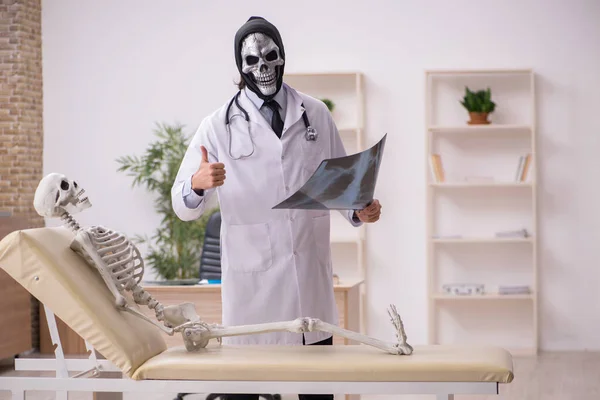 Diabo médico radiologista examinando paciente esqueleto — Fotografia de Stock