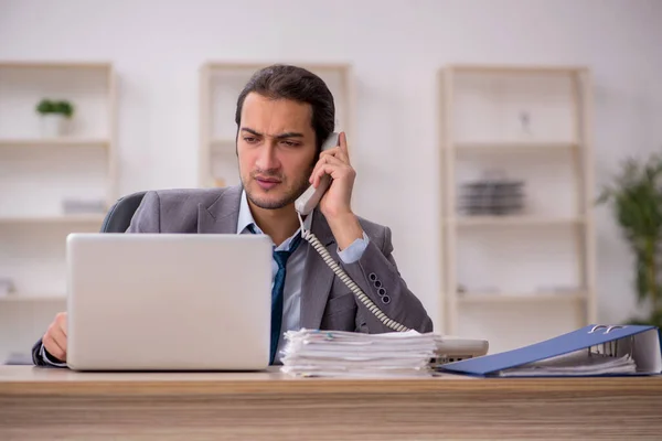 Junge männliche Angestellte unzufrieden mit exzessiver Arbeit im Büro — Stockfoto