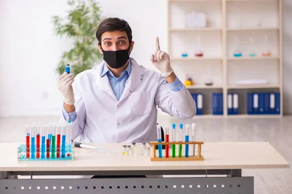 Jonge mannelijke chemicus werkt in het lab tijdens een pandemie — Stockfoto