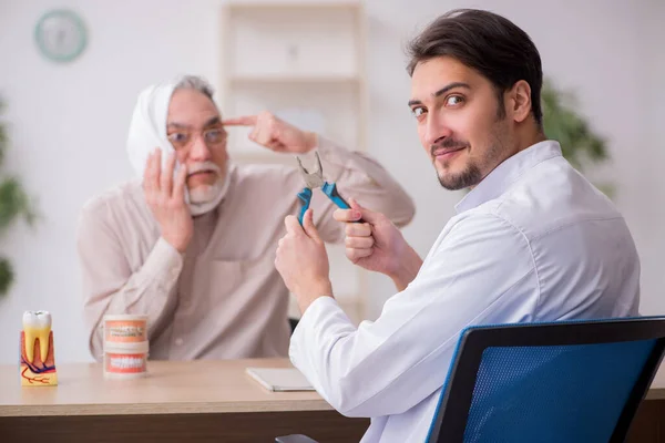 老年男性病人看年轻男性牙医 — 图库照片