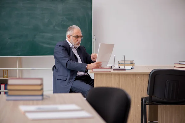 Old male teacher in front of blackboard — Stock Photo, Image