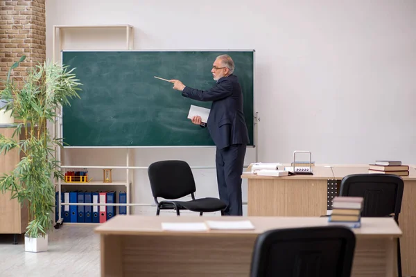 Gammal manlig lärare framför svarta tavlan — Stockfoto