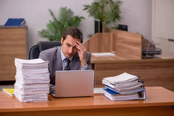 Junge männliche Mitarbeiter und zu viel Arbeit im Büro — Stockfoto