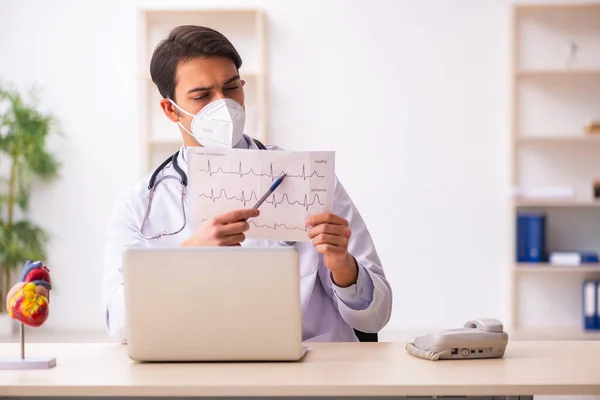 Молодий лікар-кардіолог, який працює в клініці під час пандемії — стокове фото
