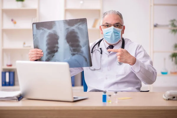 Stary lekarz radiolog pracujący w klinice podczas pandemi — Zdjęcie stockowe