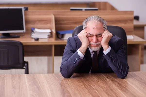 Velho empresário empregado sentado no escritório — Fotografia de Stock